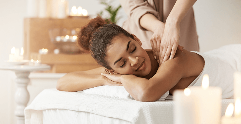 Mulher relaxada sorridente sendo massageada